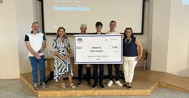 The 2026 award ceremony: Federico Roia holding the €3,000 cheque with Christian Vari and school representatives